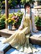 A woman in a yellow dress sitting on a wooden bench.