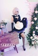 A woman in a maid outfit posing for a picture.
