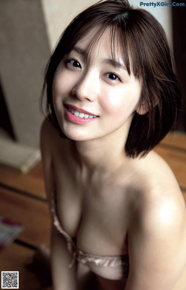 A woman in a pink lingerie posing for the camera.