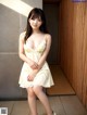 A woman in a yellow dress posing for a picture.