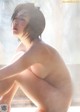 A naked woman sitting on a window sill in the rain.