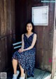 A woman sitting on a bench in front of a wooden door.