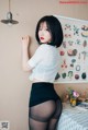 A woman in a white shirt and black skirt posing for a picture.