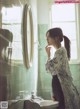 A woman standing in front of a bathroom mirror.