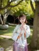 A woman in a blue and purple kimono posing for a picture.