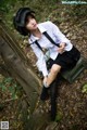 A woman in a school uniform sitting on a bench.