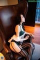 A woman sitting on a brown leather chair in a room.