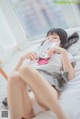 A woman laying on a bed reading a book.