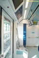 A view of the inside of a train with a blue and white seat.