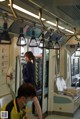 A woman wearing a face mask on a subway train.
