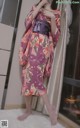 a woman in a purple kimono standing in front of a window