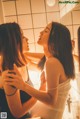 A couple of women standing next to each other in a bathroom.