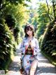 A woman in a kimono walking down a path in a park.